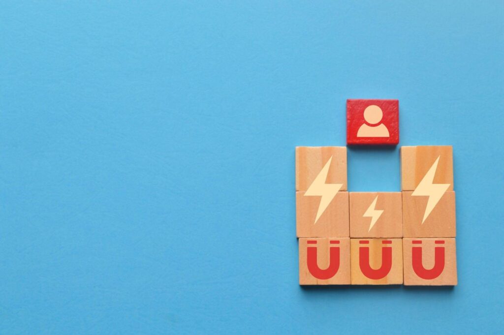 Wooden blocks with magnet icons pull a person in a row blocks. Recruiting and search talent workers